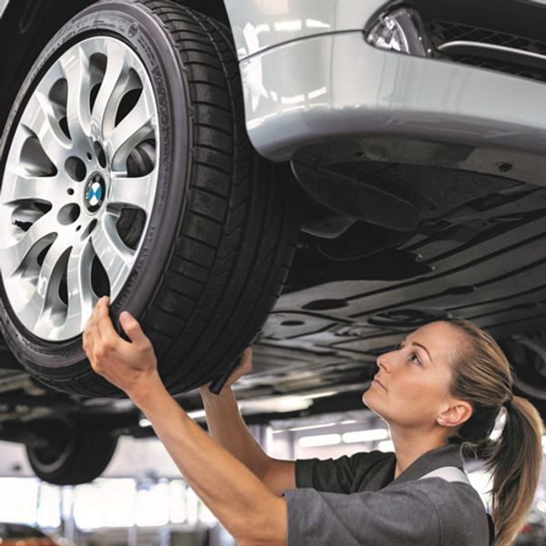 a woman technician checking a tire