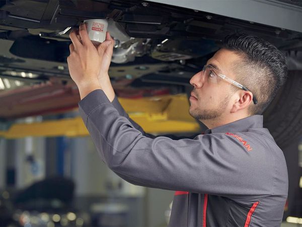 Nissan Technician Oil Change Filter Under Car